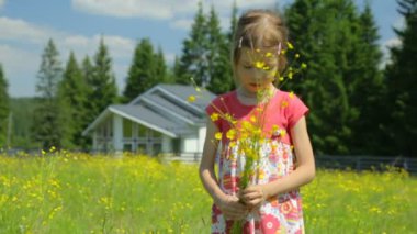 Çayırda sarı çiçekli küçük kız