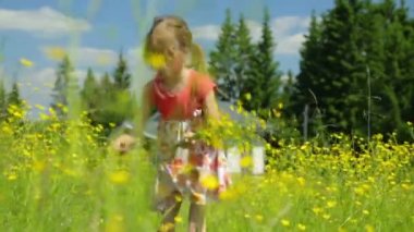 Çayırda çiçek toplayan küçük kız