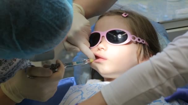 Niña en la silla del dentista teniendo su diente tratado — Vídeo de stock