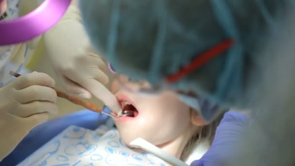 Kleines Mädchen im Zahnarztstuhl lässt sich einen Zahn behandeln — Stockvideo