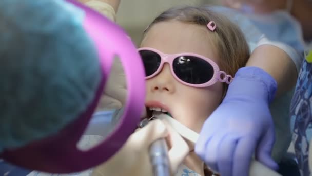 Bambina sulla sedia del dentista che si fa curare il dente — Video Stock