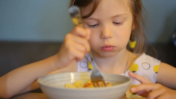 En liten flicka som äter pasta på kaféet — Stockvideo