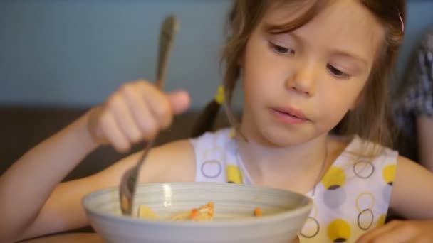 Девочка ест макароны в кафе — стоковое видео
