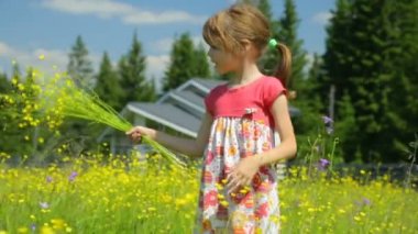 Çayırda sarı çiçekli küçük kız