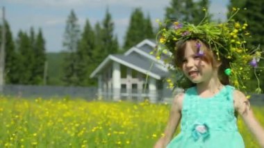 Çayır üzerinde çelengi olan küçük kız