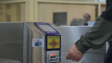 İnsanlar metroda turnikeden geçiyor.