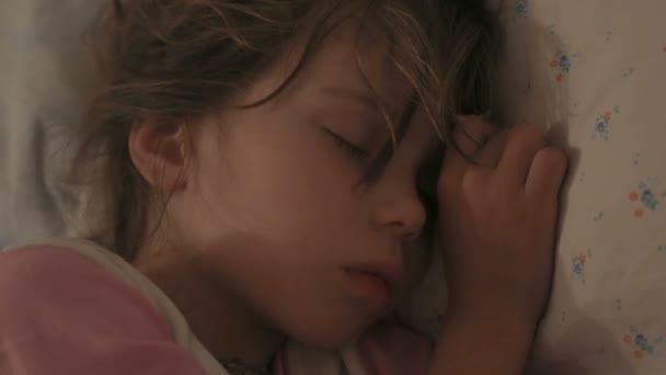 Маленькая девочка спит в своей постели — стоковое видео