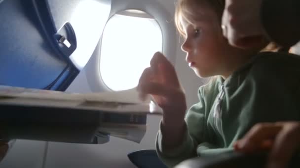 Маленькая девочка с матерью в самолёте — стоковое видео