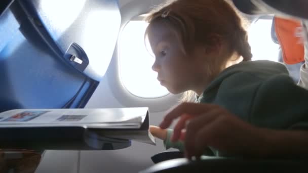 Liten flicka med mamma i flygplanet — Stockvideo