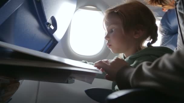 Little girl with mother in the airplane — Stock Video