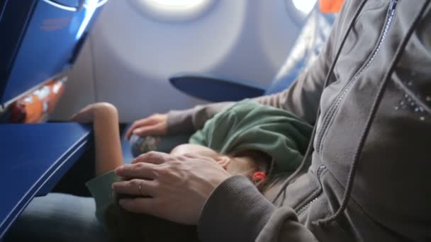 Mother with her sleeping little girl in airplane — Stock Video