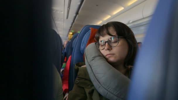 Молодая женщина спит в самолете — стоковое видео