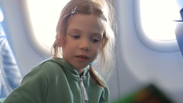 Маленькая девочка с матерью в самолёте — стоковое видео