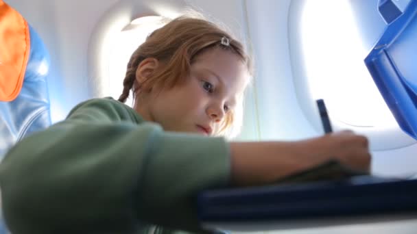 Uçakta çizim yapan küçük kız. — Stok video