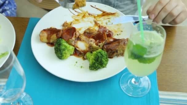 Hombre comiendo carne con brócoli en la cafetería — Vídeo de stock