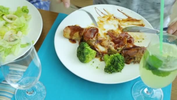 Man die vlees eet met broccoli in café — Stockvideo