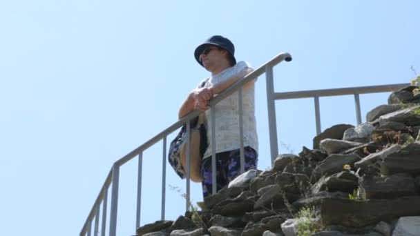 Турист на горі дивиться вниз — стокове відео