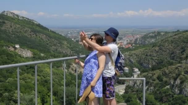 Jovem com sua esposa fazendo selfie na montanha — Vídeo de Stock