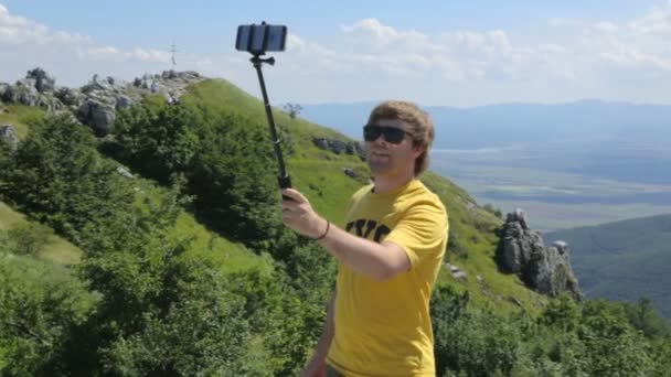 Mladý muž dělá selfie na hoře — Stock video
