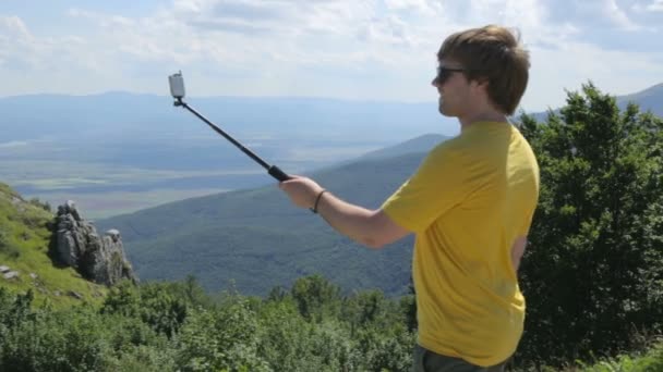 Mladý muž dělá selfie na hoře — Stock video
