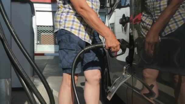 Conductor repostando un coche en una gasolinera — Vídeo de stock