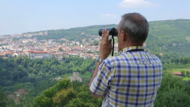 Turista masculino olhando através de binóculos — Vídeo de Stock