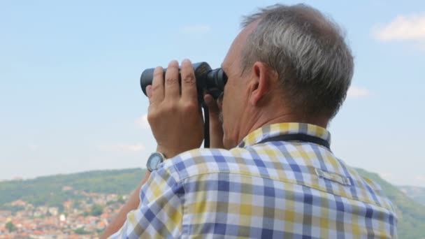 Turista masculino mirando a través de prismáticos — Vídeos de Stock