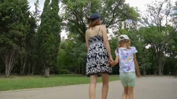 Femme avec fille marchant dans le parc — Video