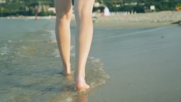 Frau läuft an Sommertag an Küste entlang — Stockvideo
