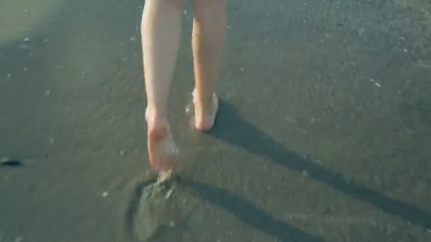 Жінка ходить уздовж узбережжя в літній день — стокове відео