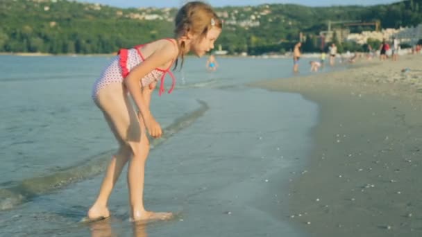 Маленькая девочка на побережье в летний день — стоковое видео
