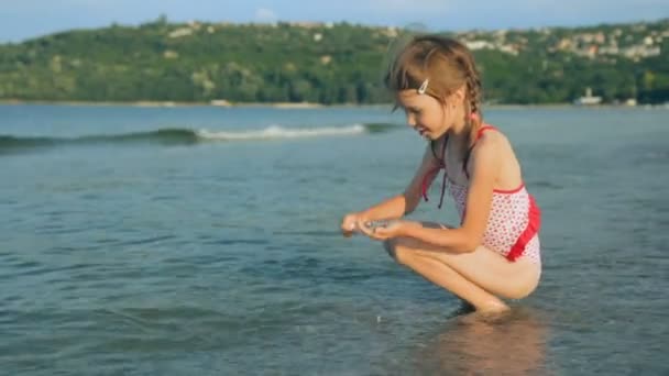 Маленька дівчинка на узбережжі в літній день — стокове відео