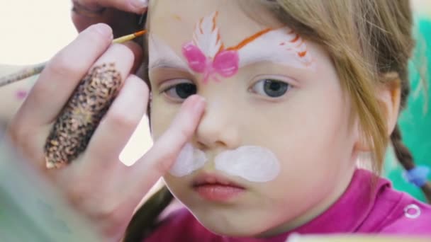 Mujer pintando en la cara de un niño. Arte corporal . — Vídeos de Stock