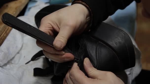 Обувщик чинит обувь в мастерской — стоковое видео