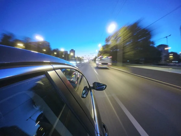 Auto se pohybuje vysokou rychlostí na silnici noci ve městě. — Stock fotografie