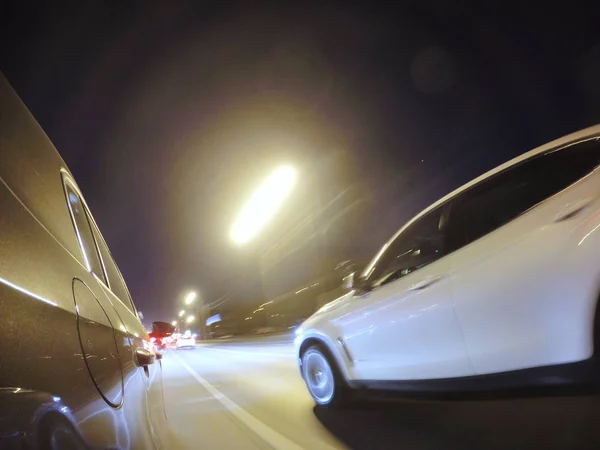 Araba gece şehir yolda yüksek hızda hareket ediyor.