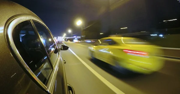 Bilen är i rörelse i hög hastighet på vägen natt staden. — Stockfoto