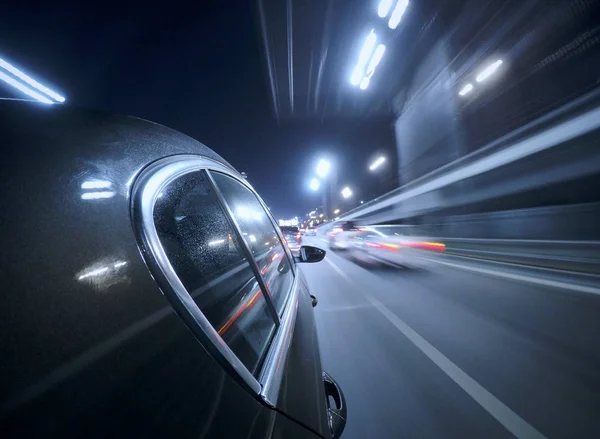 Araba gece şehir yolda yüksek hızda hareket ediyor.