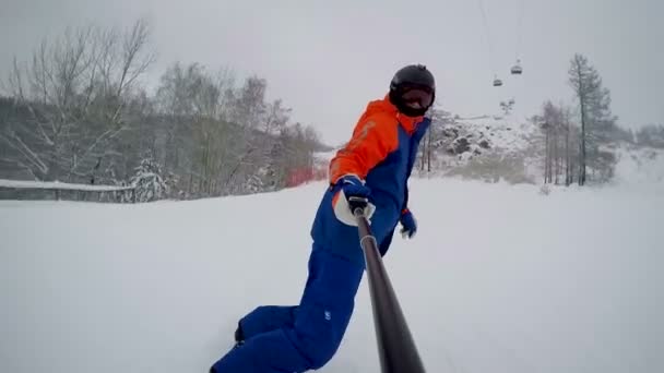 Snowboardzista Zjeżdża Góry Nartostradzie Pod Wyciągiem Widok Przodu Selfie Stick — Wideo stockowe