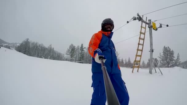 Snowboarder Makes Finger Gesture Begins Descent Mountain Front View Selfie — Stock Video