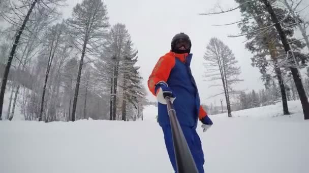 Snowboarder Descends Mountain Winter Forest Skier Background View Selfie Stick — Stock Video