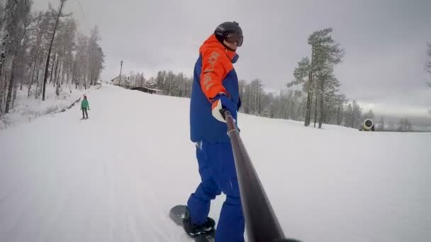 Snowboardåkare Stiger Ner Från Berget Vid Solnedgången Utsikt Från Selfiepinne — Stockvideo