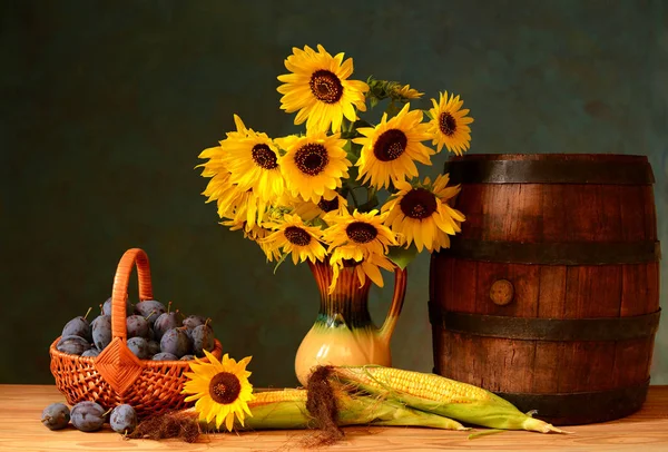 Wooden barrel, sunflowers in a vase and plum — Stock Photo, Image