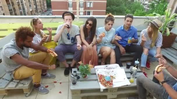 Vänner som äter pizza på taket — Stockvideo