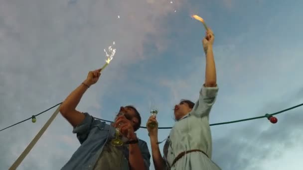 Pareja ondeando con velas de fuegos artificiales — Vídeo de stock