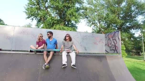 Друзья сидят на рейнджере в скейтпарке — стоковое видео