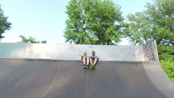 Man en vrouw die kijken naar vriend skateboarden — Stockvideo