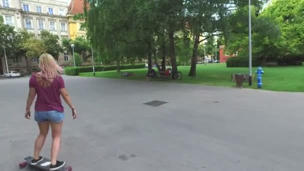 Kadın parkta bir longboard üzerinde — Stok video