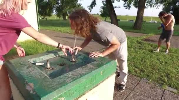 Друзья, освежающие питьевой фонтан — стоковое видео