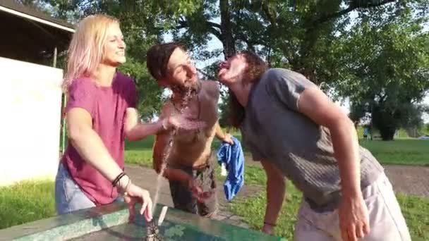 Freunde erfrischen sich am Trinkbrunnen — Stockvideo